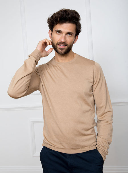 Man wearing light camel long sleeved crewneck sweater knit in 100% luxury and premium merino wool.